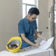 亚洲男性工程师在装修工地处理施工图纸 80x80